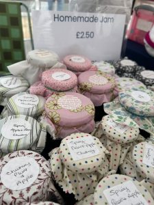 Jars of home made jam with fabric toppers